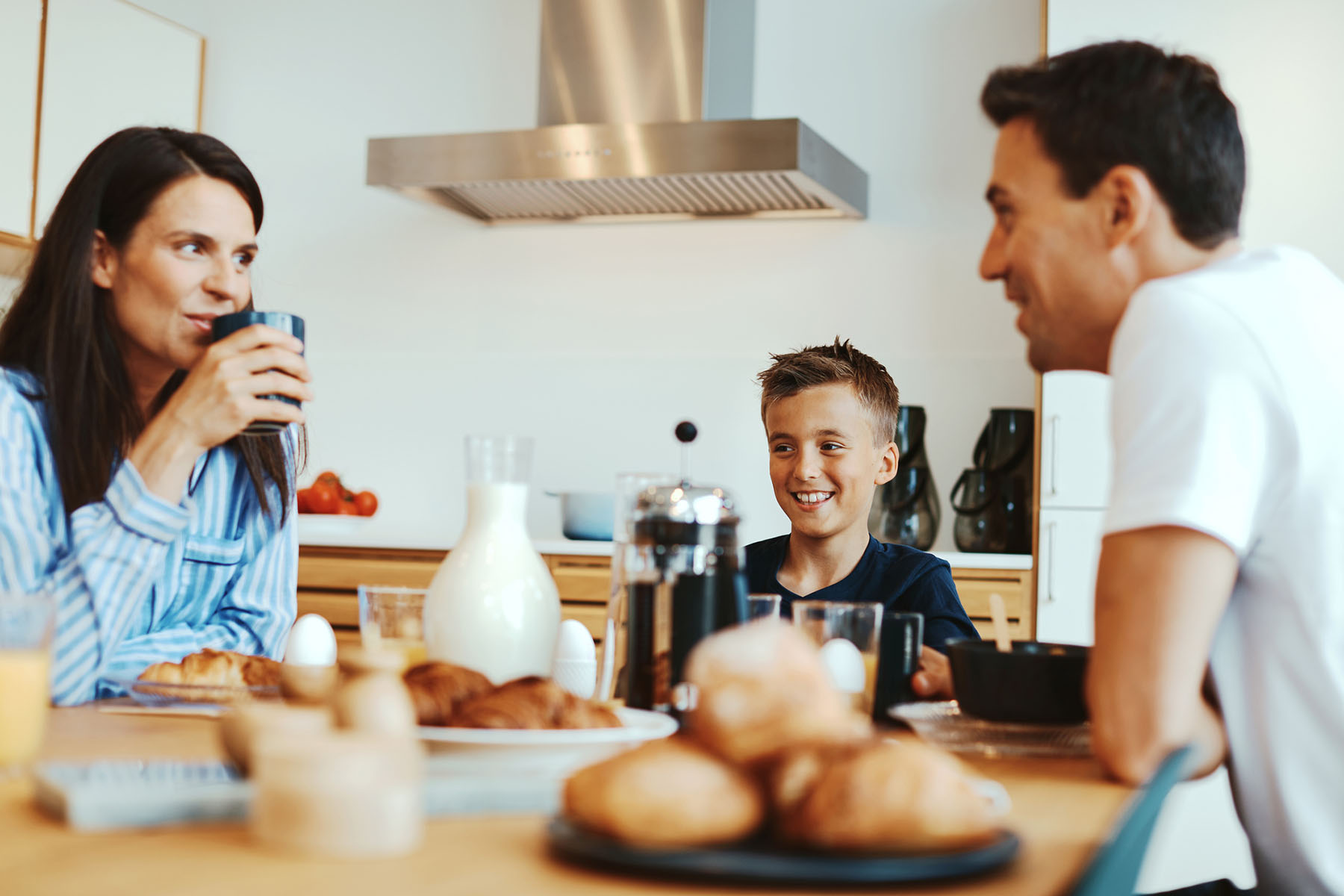 Family enjoying breakfast together in a bright kitchen, reflecting stronger communication and connection supported by family therapy