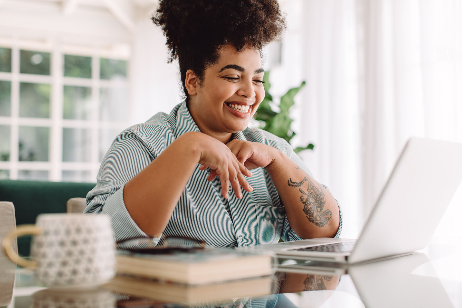 Joyful woman engaging in virtual therapy session on laptop, representing accessible telehealth counseling options for emotional support