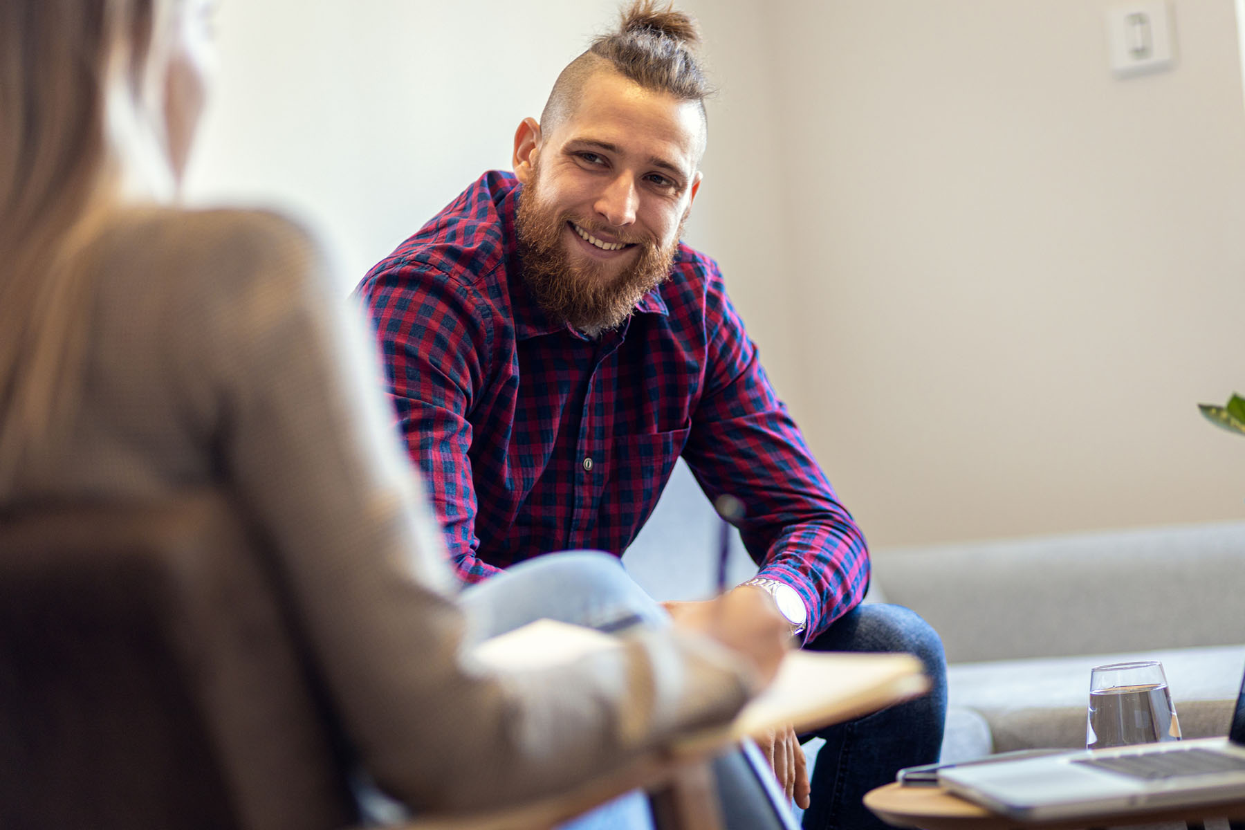 Man smiling during a one-on-one counseling session, capturing trust and openness in mental health therapy at Vivus Counseling
