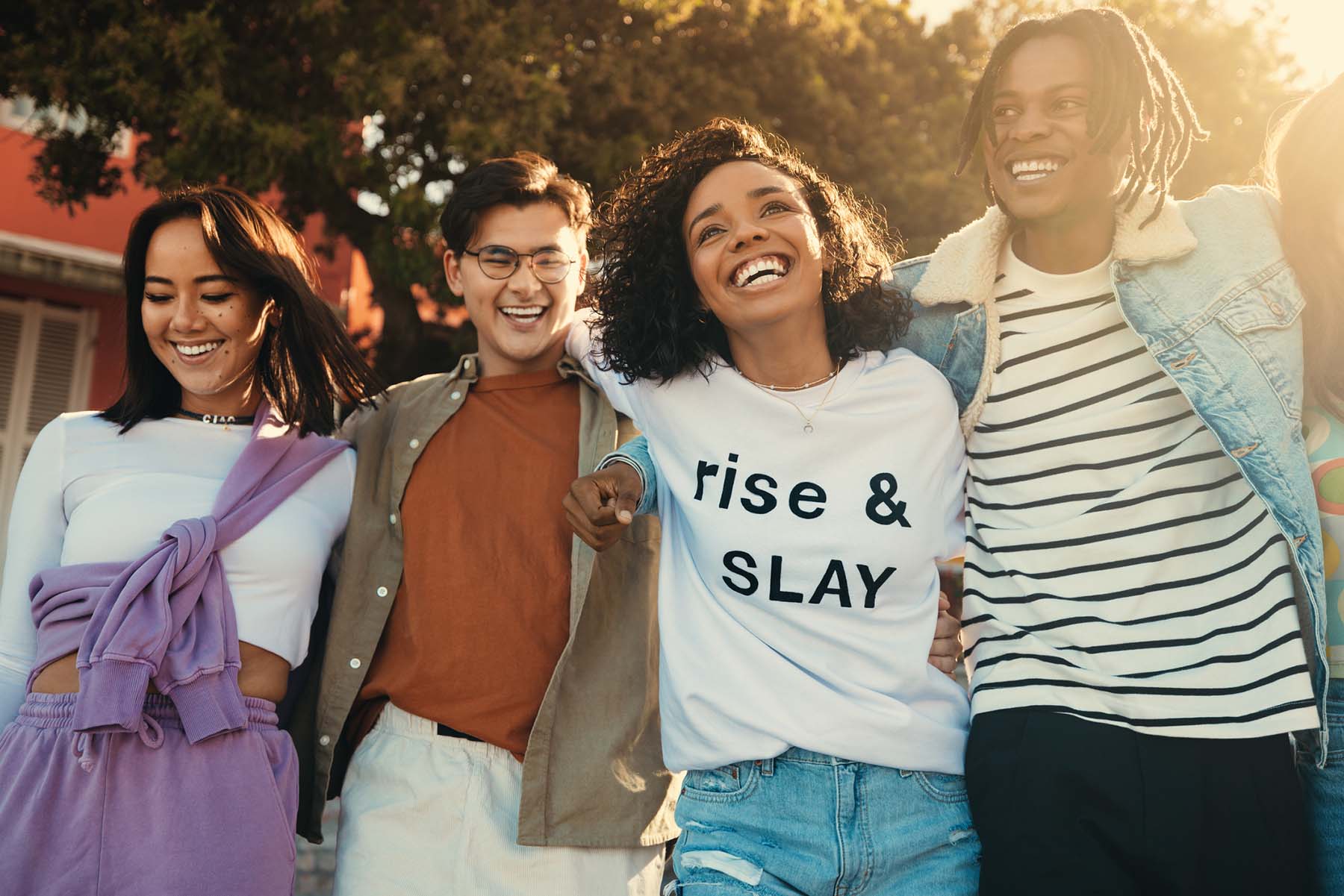 Diverse group of young adults smiling and walking arm-in-arm, representing inclusive community and support for mental health and belonging at Vivus Counseling
