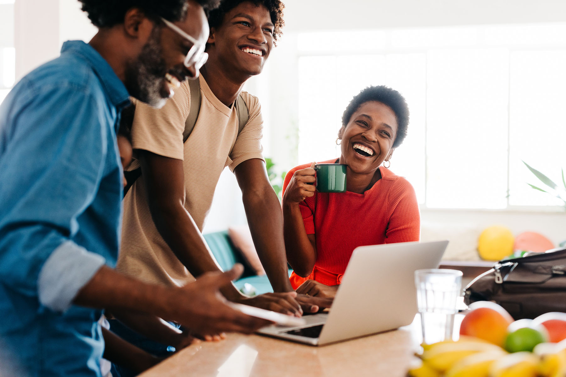 Smiling family gathered around a laptop in a bright kitchen, reflecting warmth, connection, and positive mental health support at Vivus Counseling
