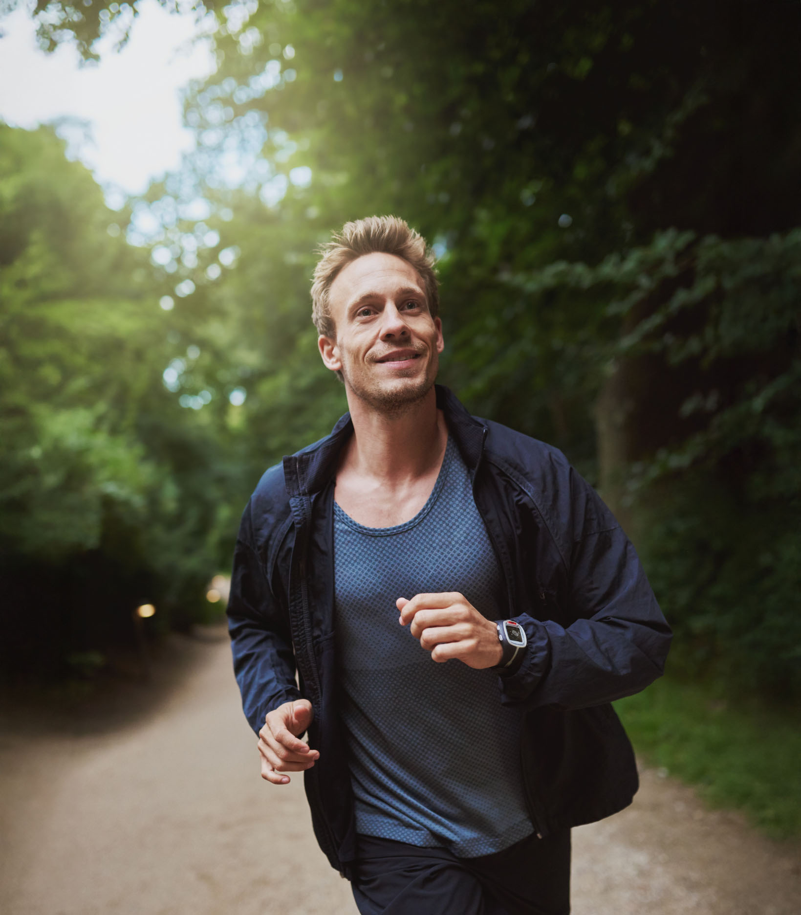 Young man jogging on a forest path, symbolizing emotional resilience, physical wellness, and the benefits of mental health counseling for building healthy coping strategies.