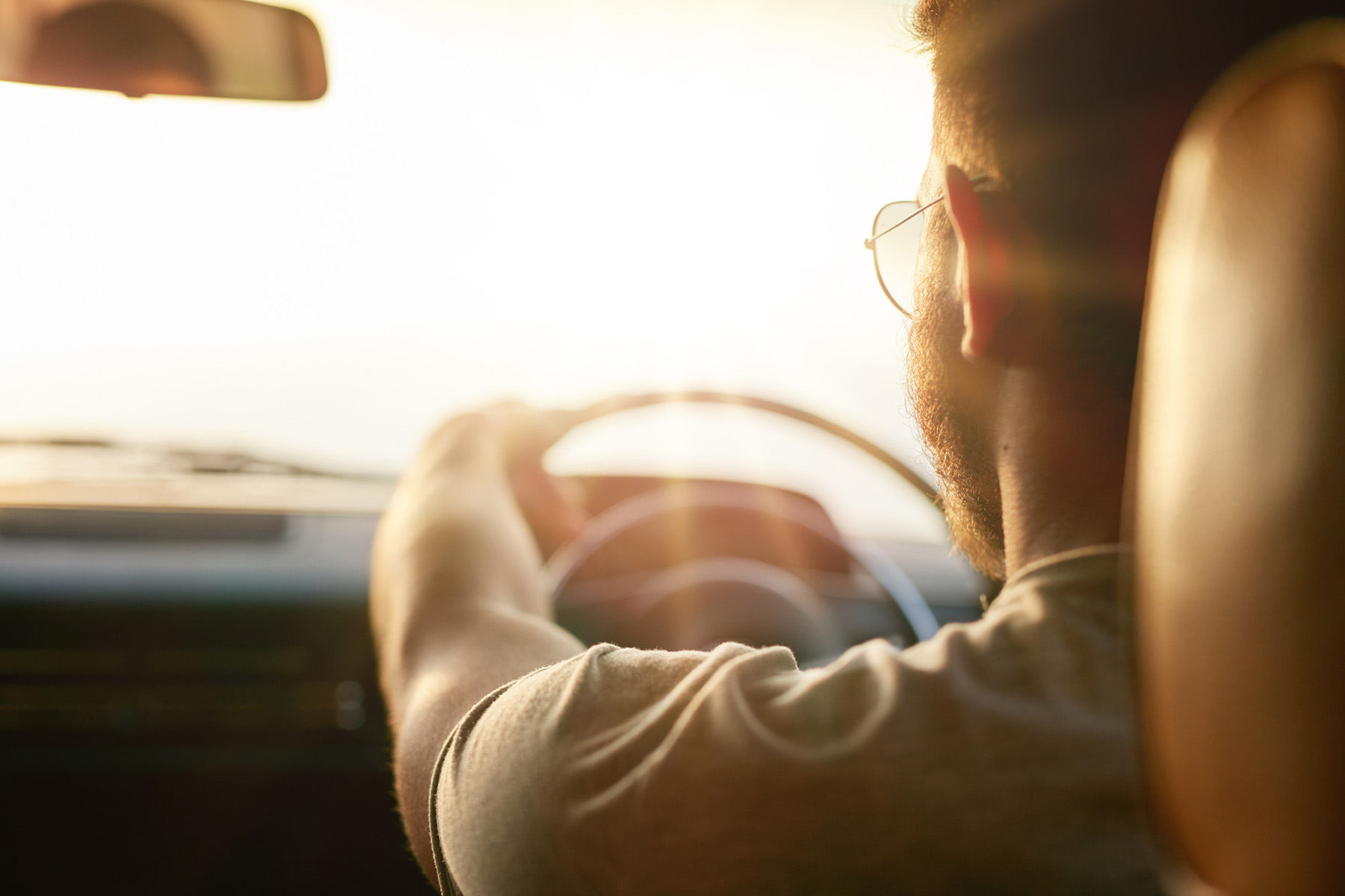 Man driving a car at sunrise, symbolizing the journey toward personal growth and accountability through DUI counseling support