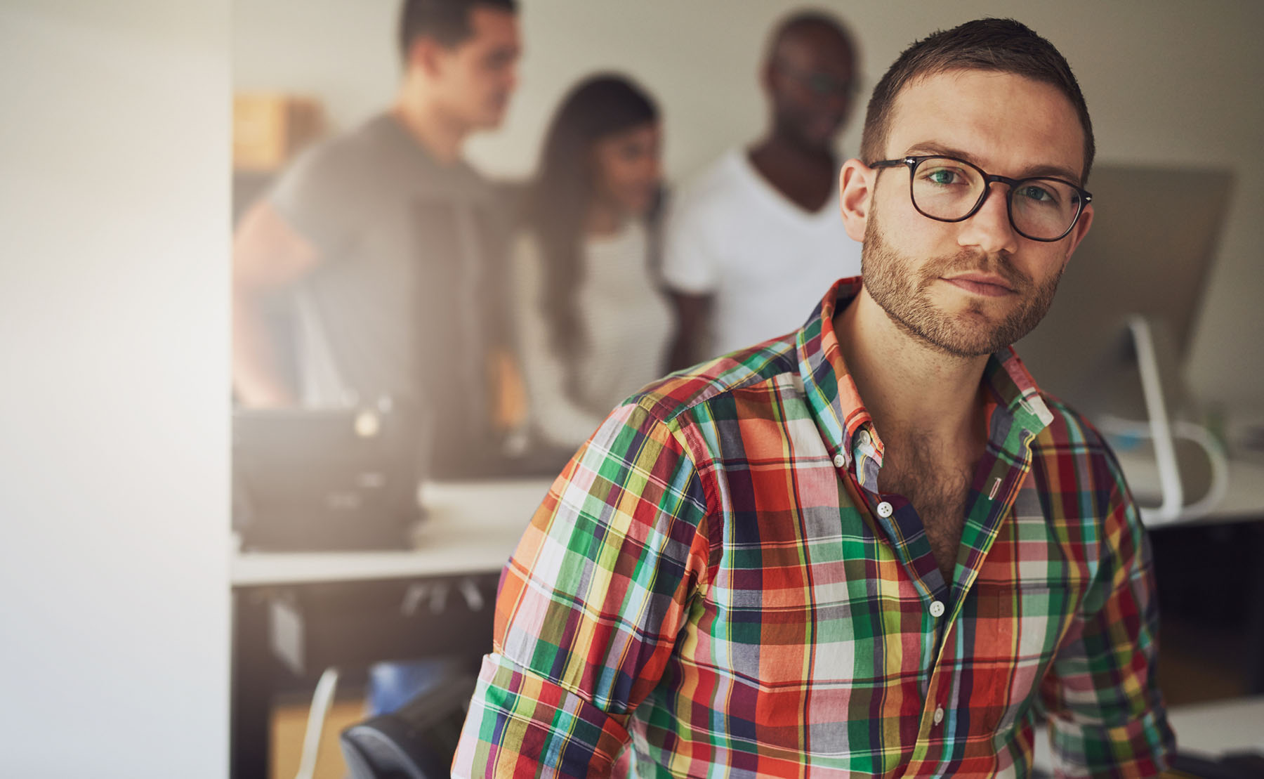Serious-looking man in a modern office environment, reflecting internal struggle and the importance of seeking mental health counseling